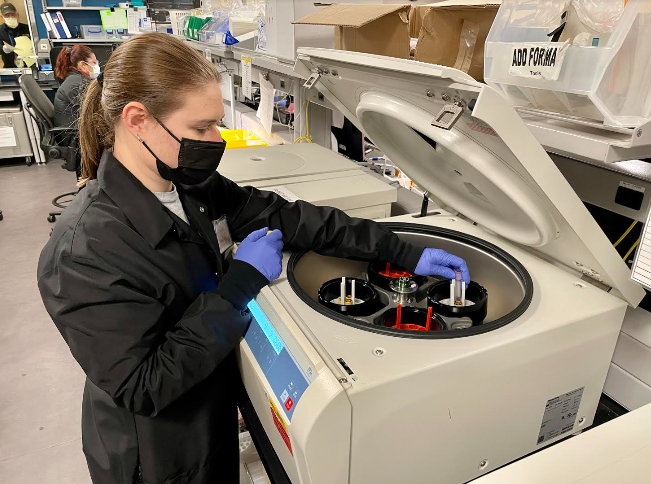 Liz Feldcamp loads the centrifuge to spin down blood products for testing
